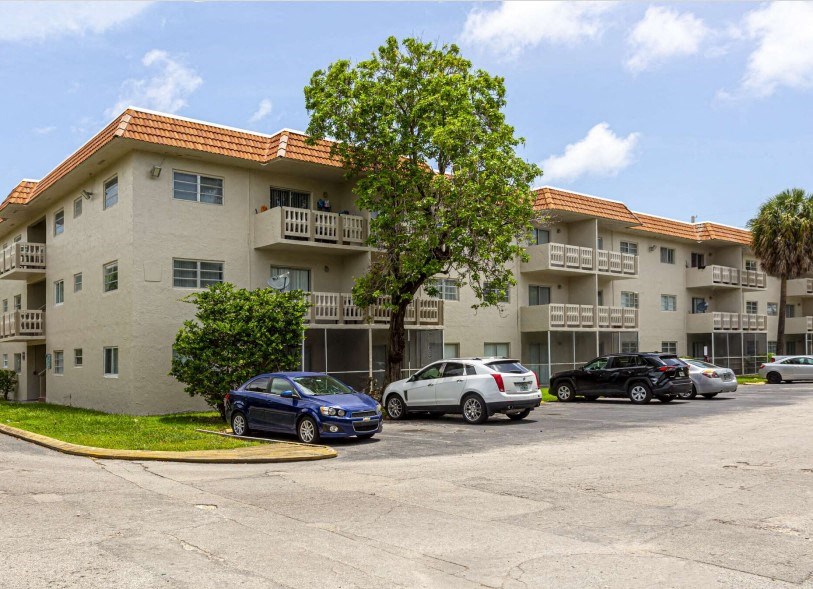 an apartment building with cars parked in front of it