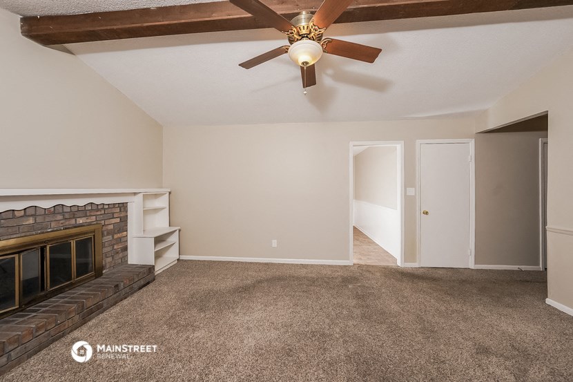 a living room with a fireplace and a ceiling fan