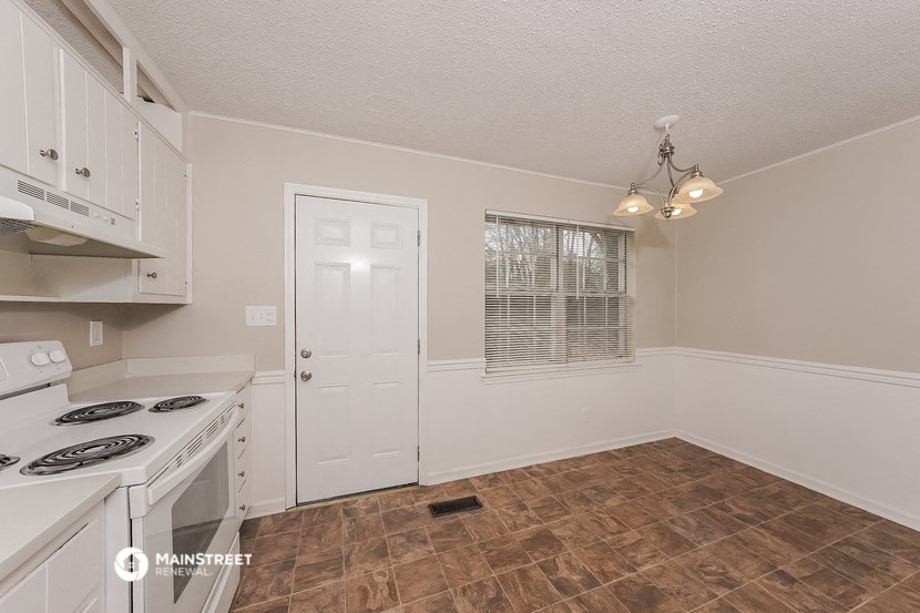 a kitchen with a stove and a white door