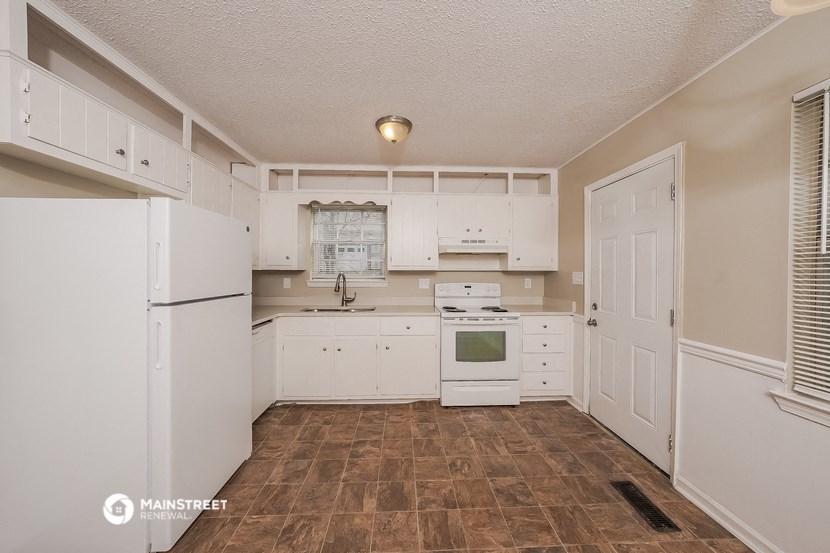 a white kitchen with white appliances and white cabinets