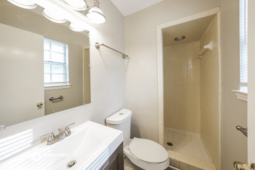 a bathroom with a shower and a sink and a toilet