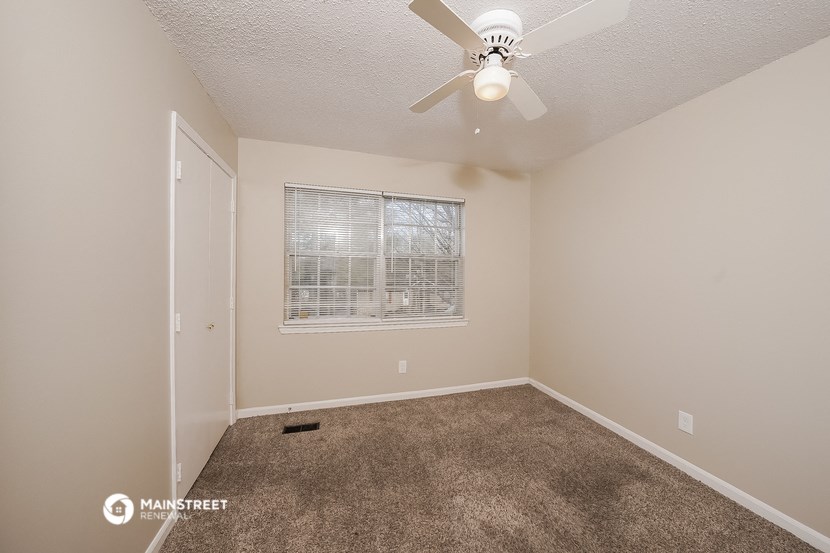 a bedroom with carpet and a ceiling fan
