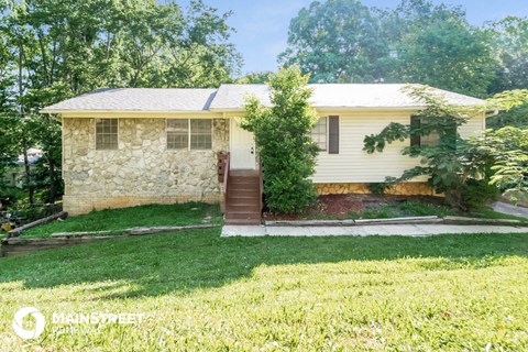 a small white house with a yard and stairs