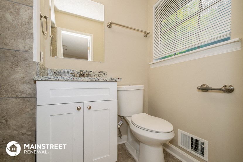 a bathroom with a toilet and a sink and a window