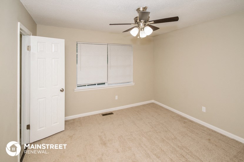 a bedroom with a ceiling fan and a window