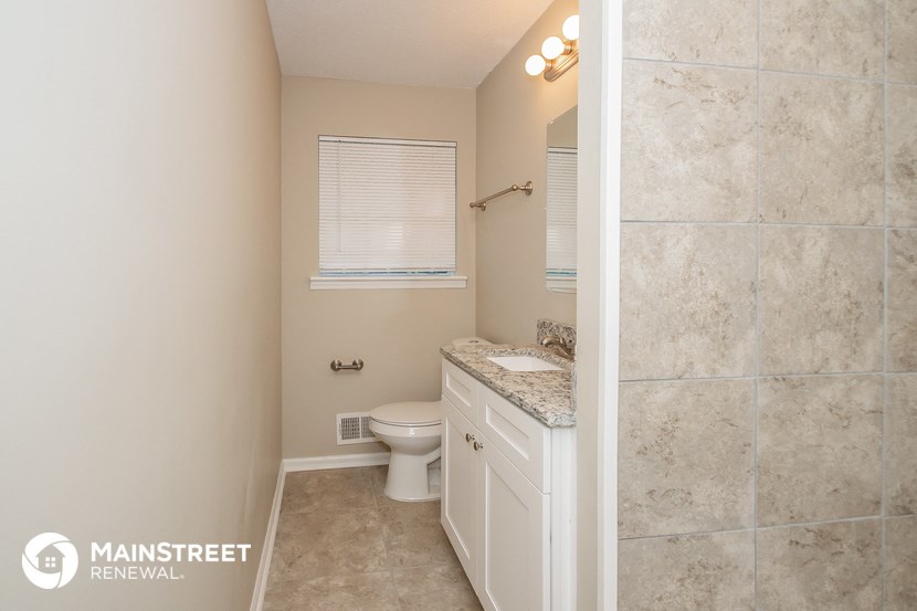 a bathroom with a toilet and a sink and a window