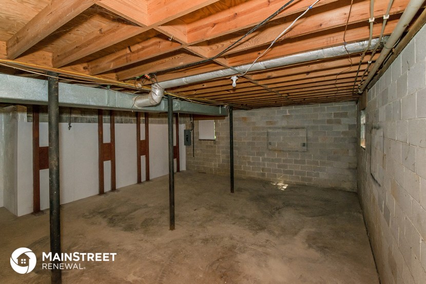 a basement with concrete floors and a brick wall