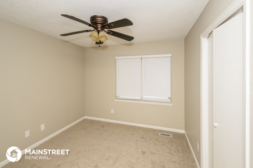 a bedroom with a ceiling fan and a window