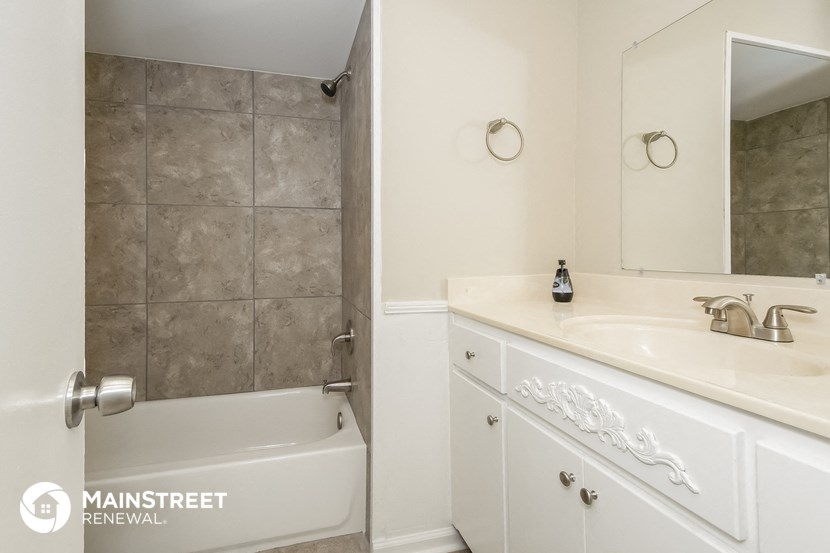 a bathroom with a sink and a tub and a mirror