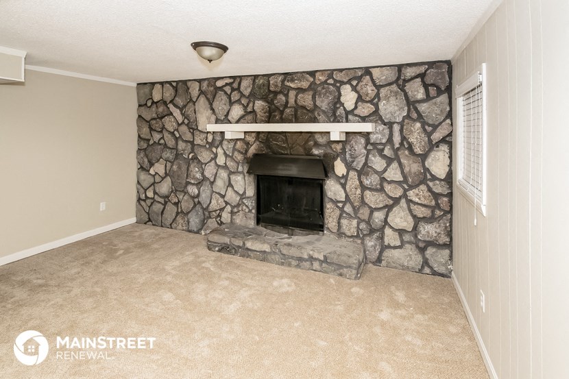 a living room with a fireplace and a stone wall