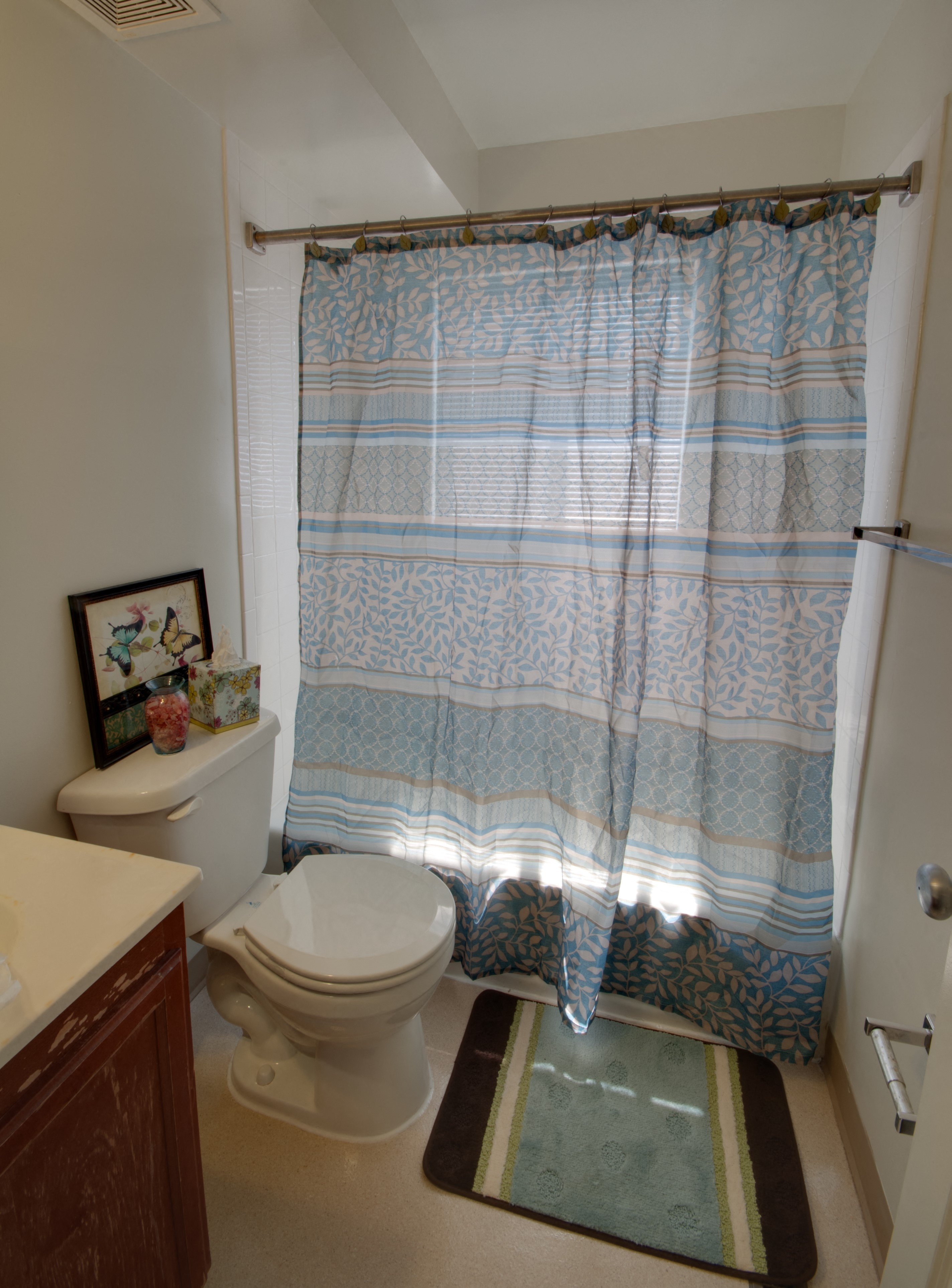 a bathroom with a toilet and a shower curtain
