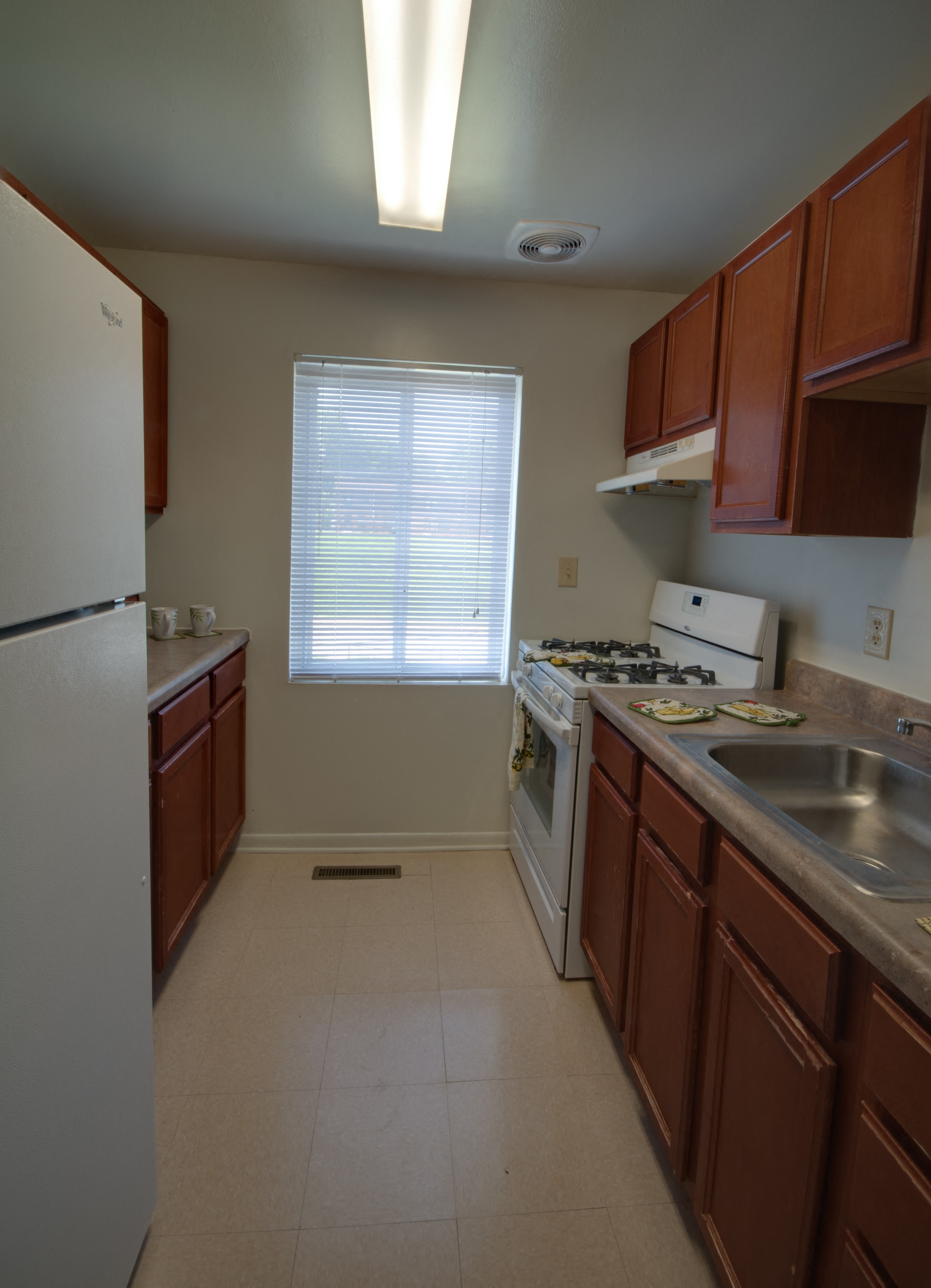 a kitchen with a stove refrigerator and sink