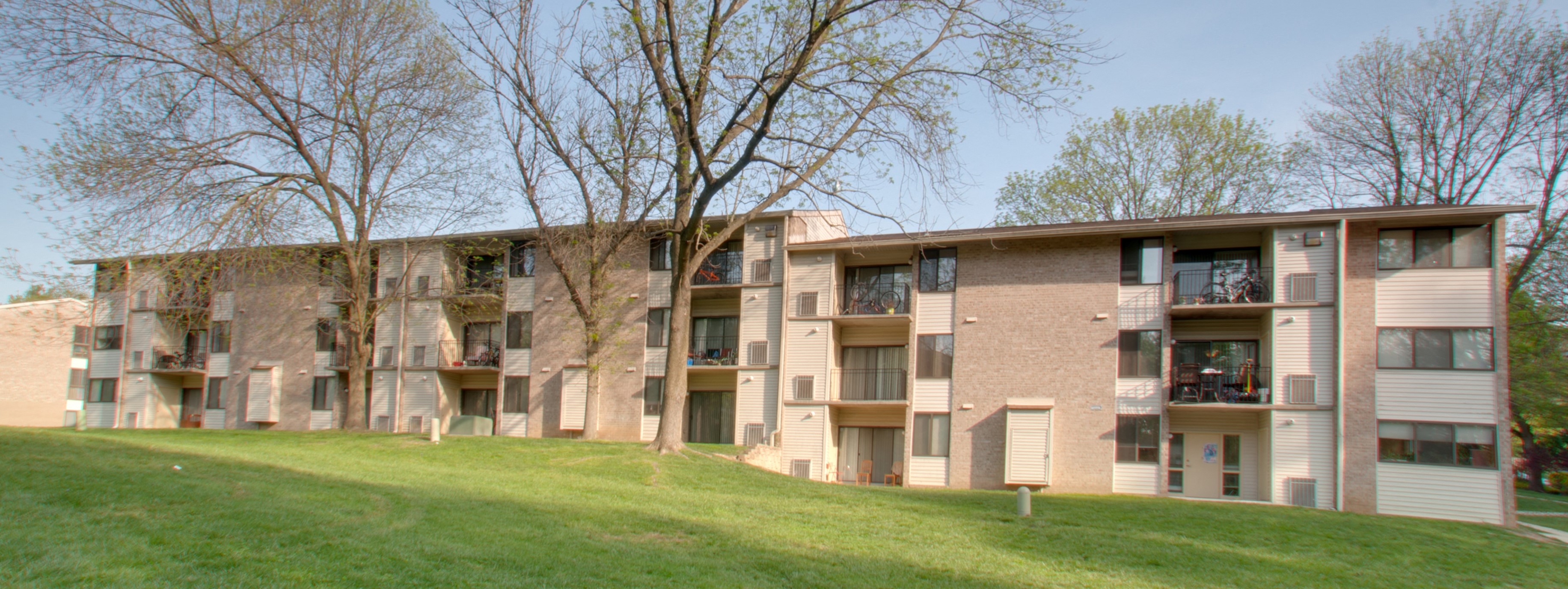the outlook of an apartment building with balconies and a green lawn
