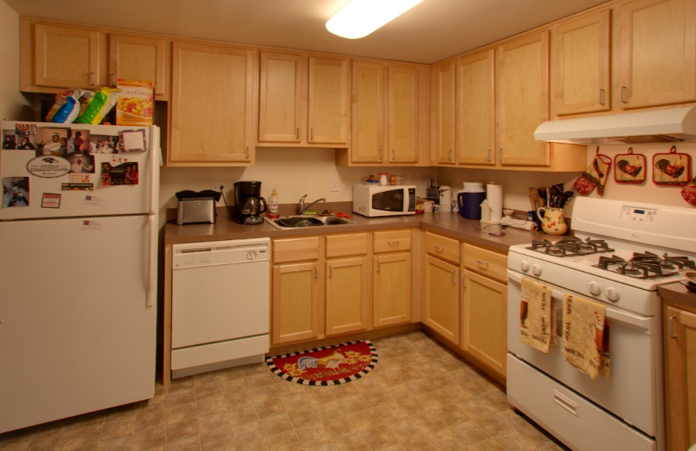 a kitchen with white appliances and wooden cabinets