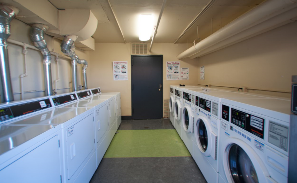a washer and dryer room in a laundromat with white washing machines