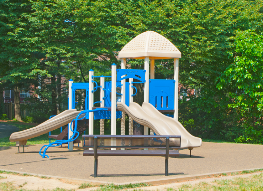 a playground with slides and a bench in a park