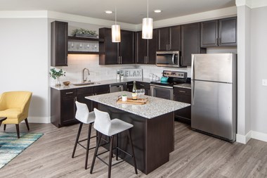 a kitchen with a large island and stainless steel appliances