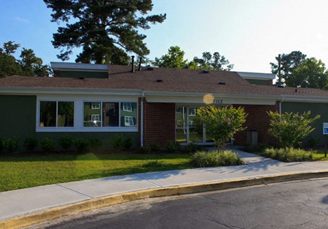 A small building with a green lawn in front.