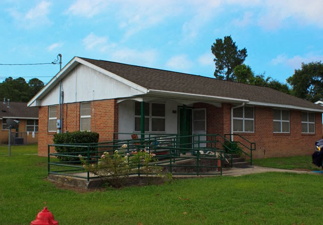 a red brick house with a porch and a red fire hydrant