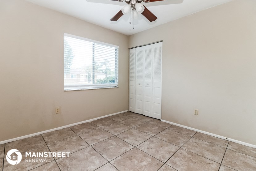 the living room of this home has tile flooring and a ceiling fan