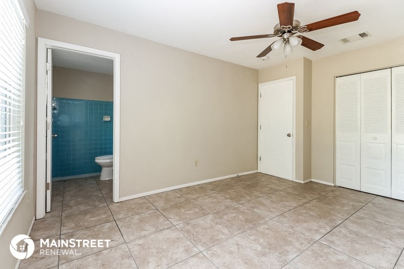 the master bedroom has a tile floor and a ceiling fan