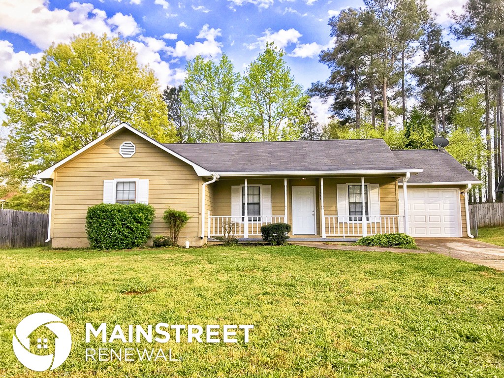 a yellow house with a lawn in front of it