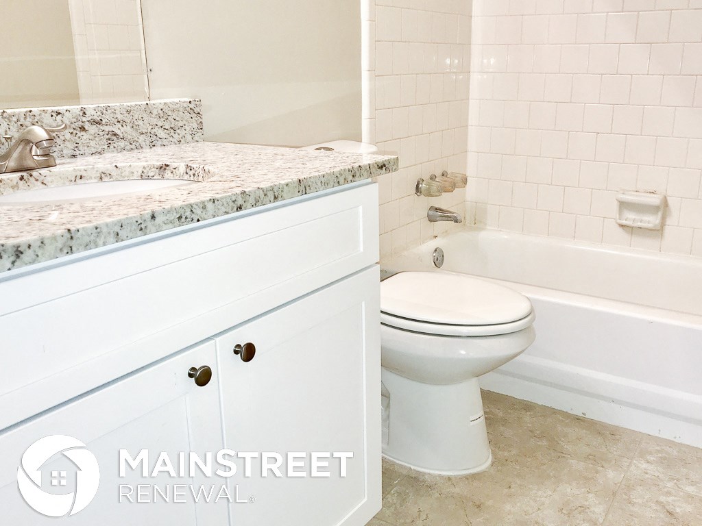 a bathroom with a toilet and a sink and a tub