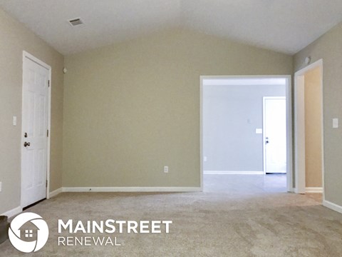 a master bedroom with a carpeted floor and a door to a closet