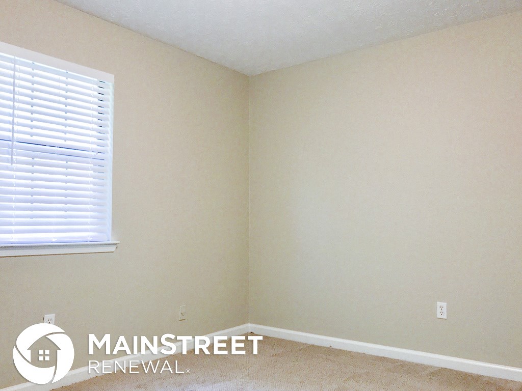 a corner of a room with a window and white walls