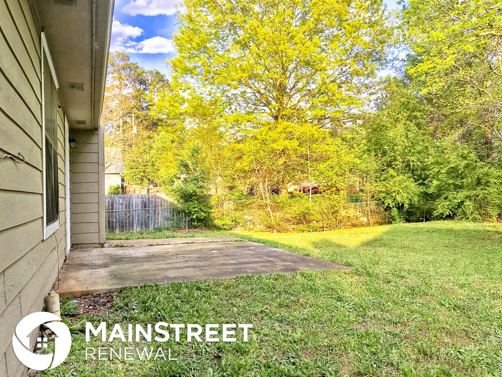 a backyard with a house and a yard and trees