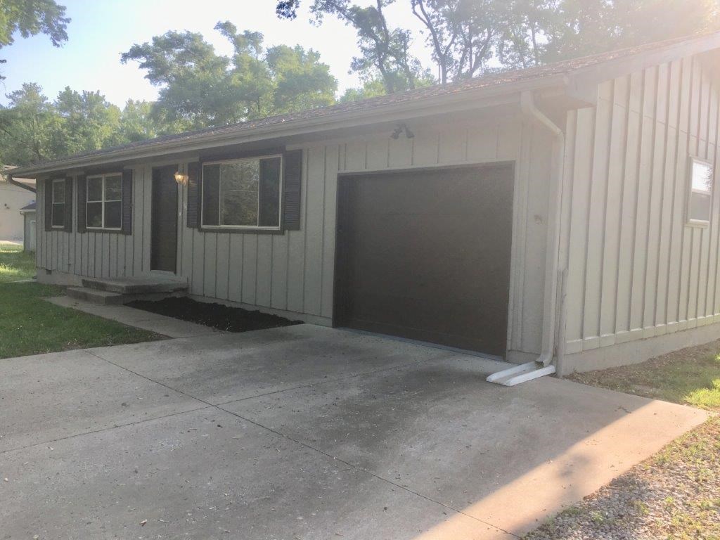 a white house with a garage with a driveway