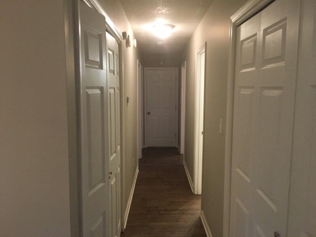 a hallway with white doors and a light on the ceiling