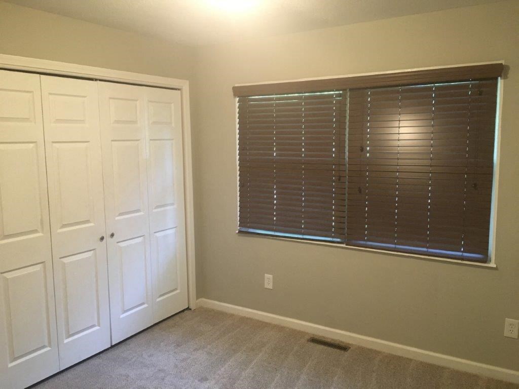 an empty room with a window and two doors