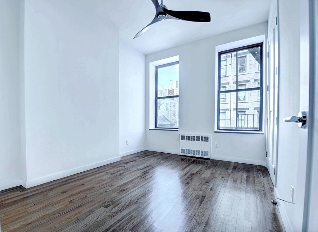 an empty living room with hardwood floors and a window