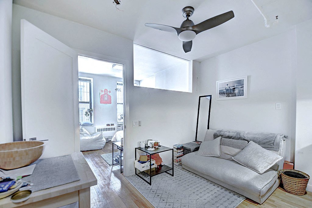 a living room with a couch and a ceiling fan
