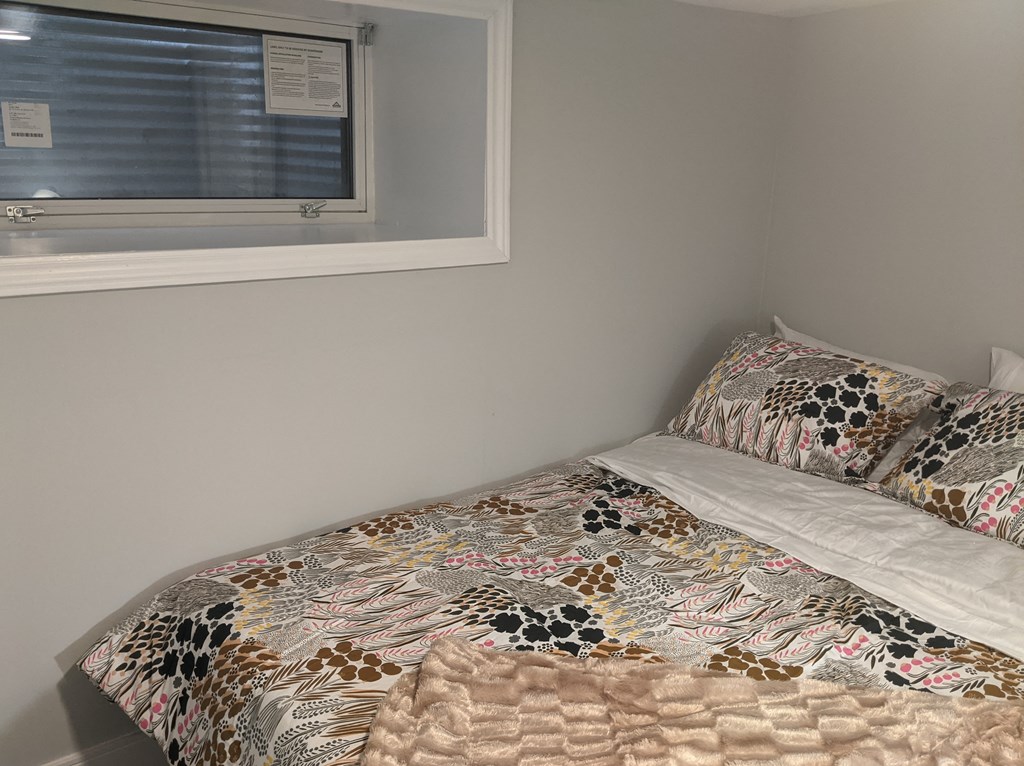 a small bedroom with a bed and a window