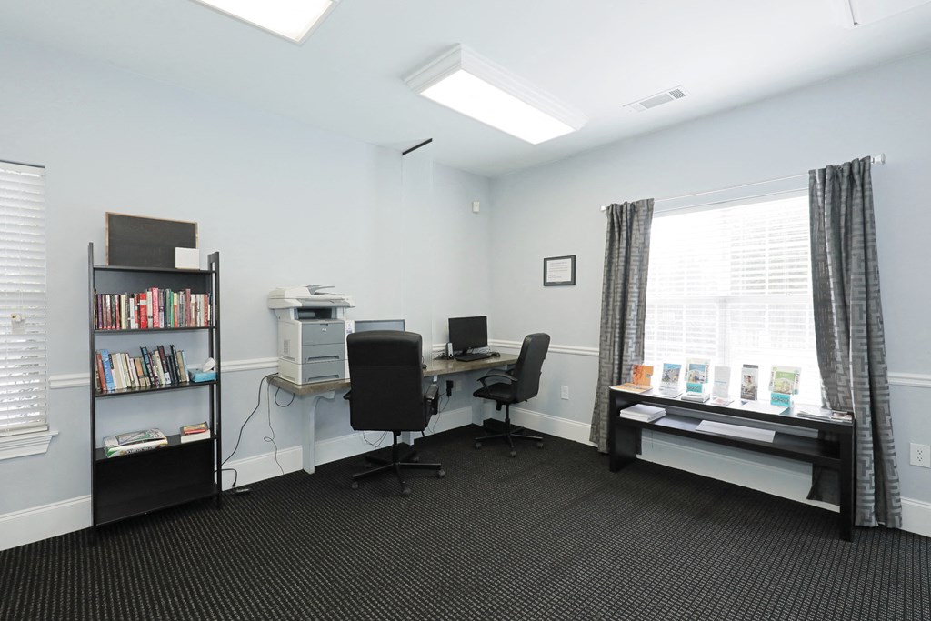 an office with a desk and a computer and a window