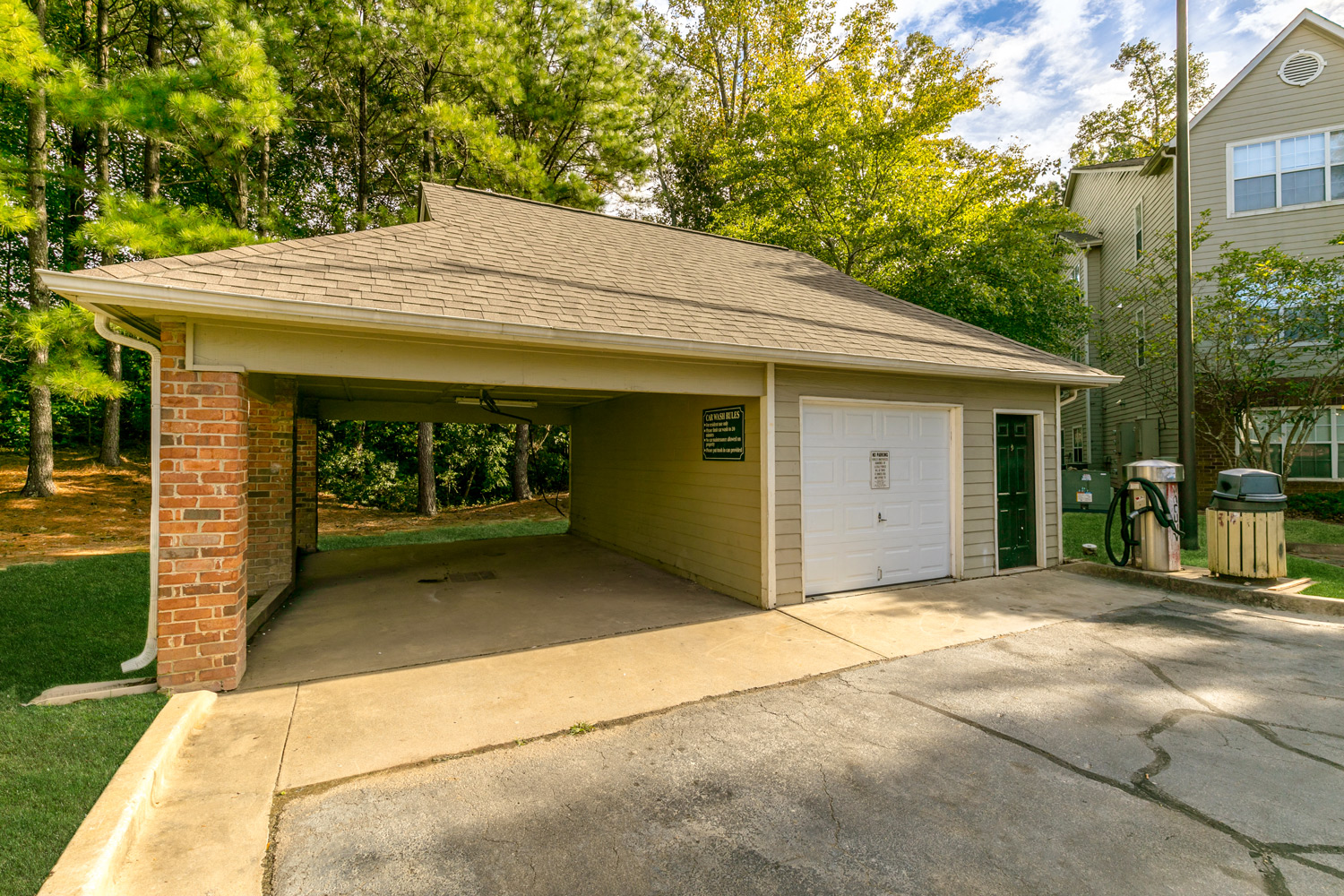 a small garage with a driveway in front of a house