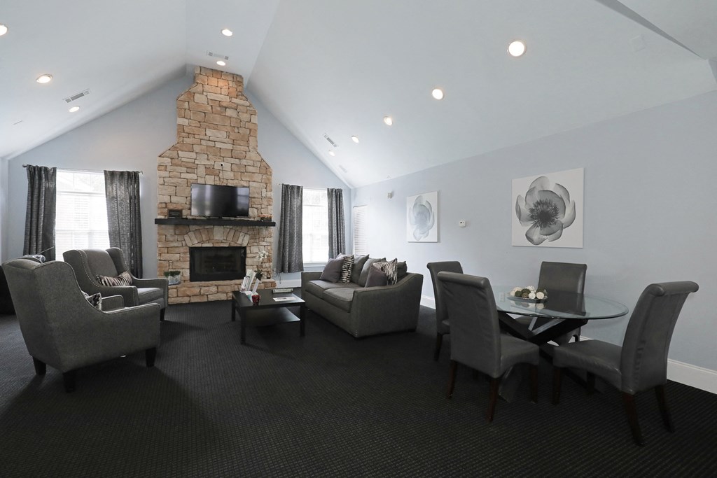 the living room has a large stone fireplace and couches and chairs