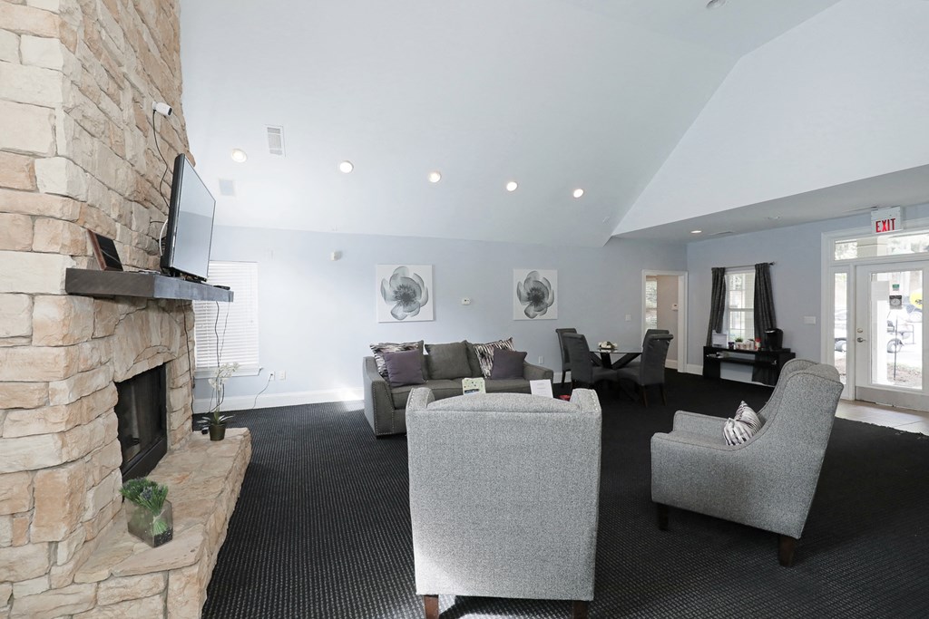 the living room has a large stone fireplace and couches