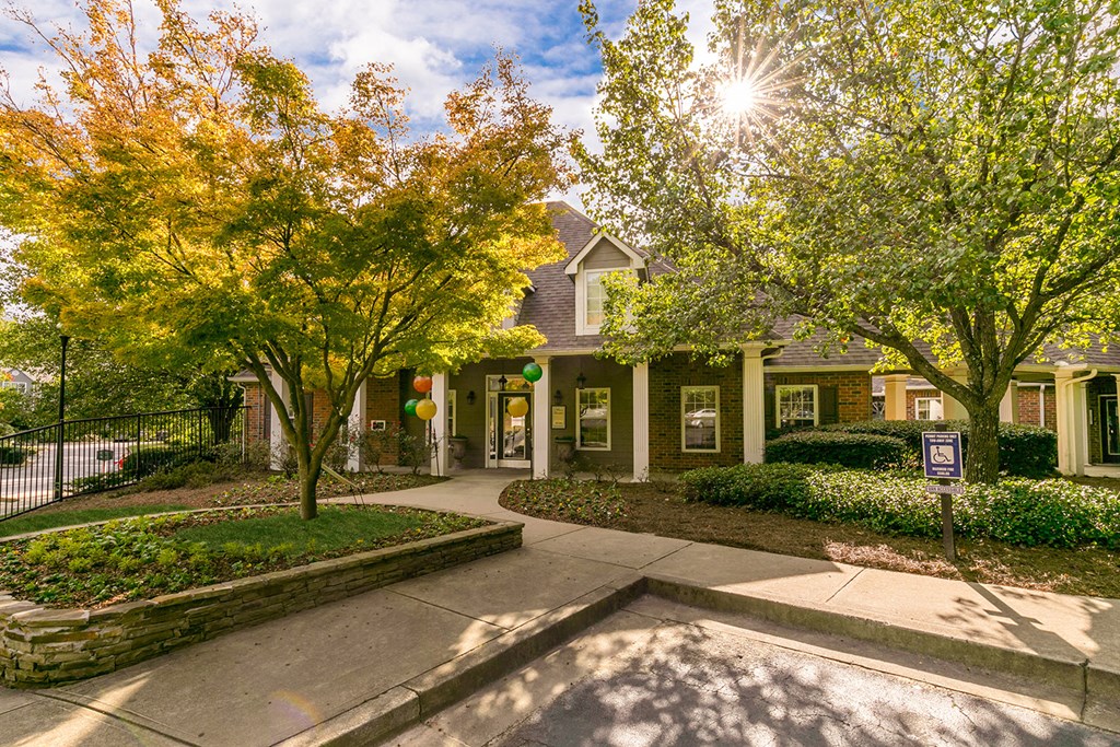 the front of a house with trees and a sidewalk