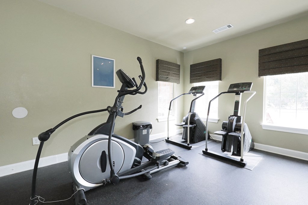 a home gym with exercise equipment and windows