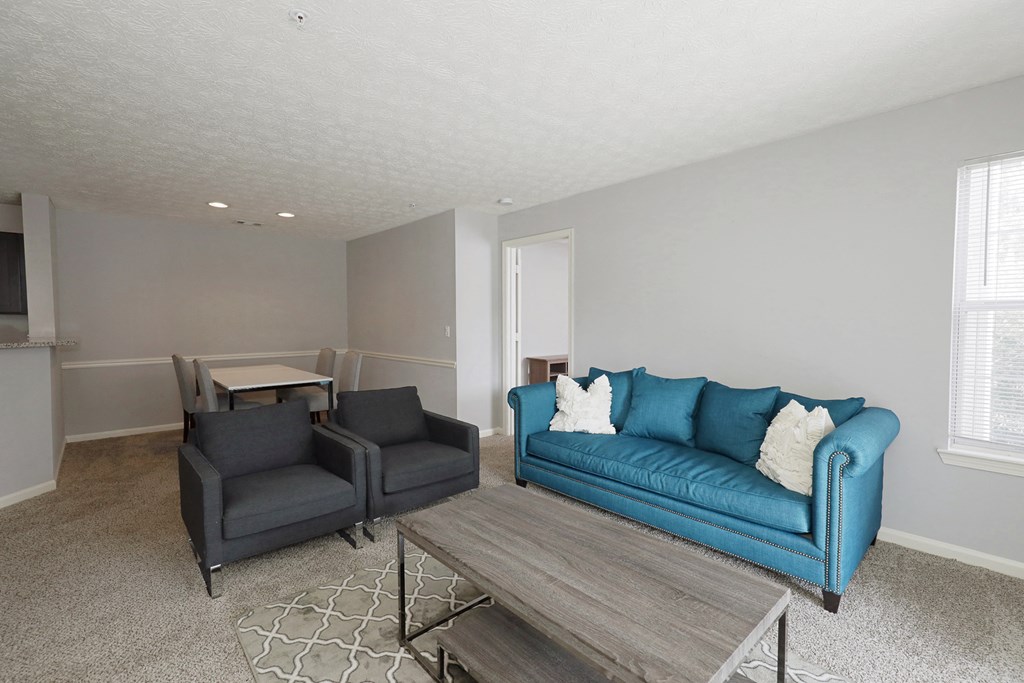 a living room with a blue couch and a table and chairs