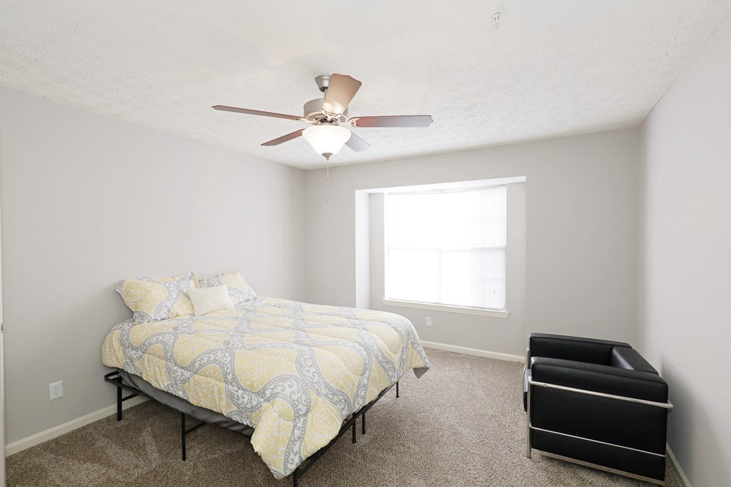 a bedroom with a bed and a ceiling fan
