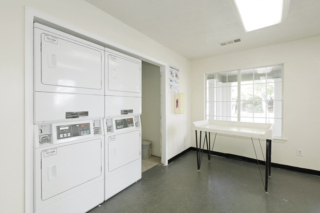 a kitchen with white appliances and a table and a window