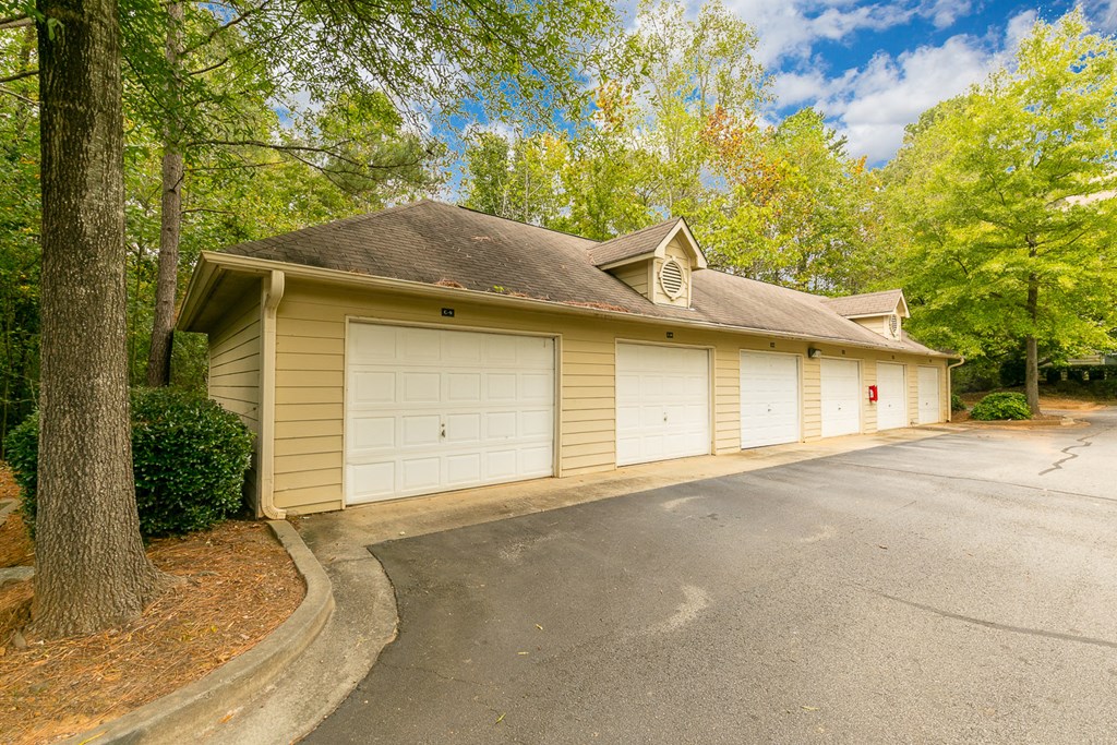 a yellow garage with white doors on the side of a street