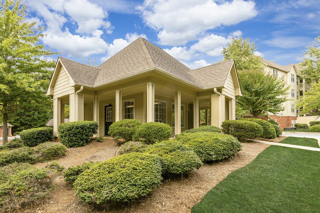 a house with a lawn and bushes in front of it