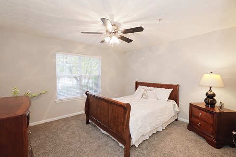 a bedroom with a bed and a ceiling fan