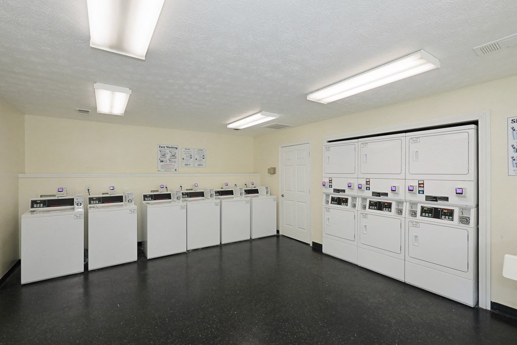 a group of washers and dryers in a utility room