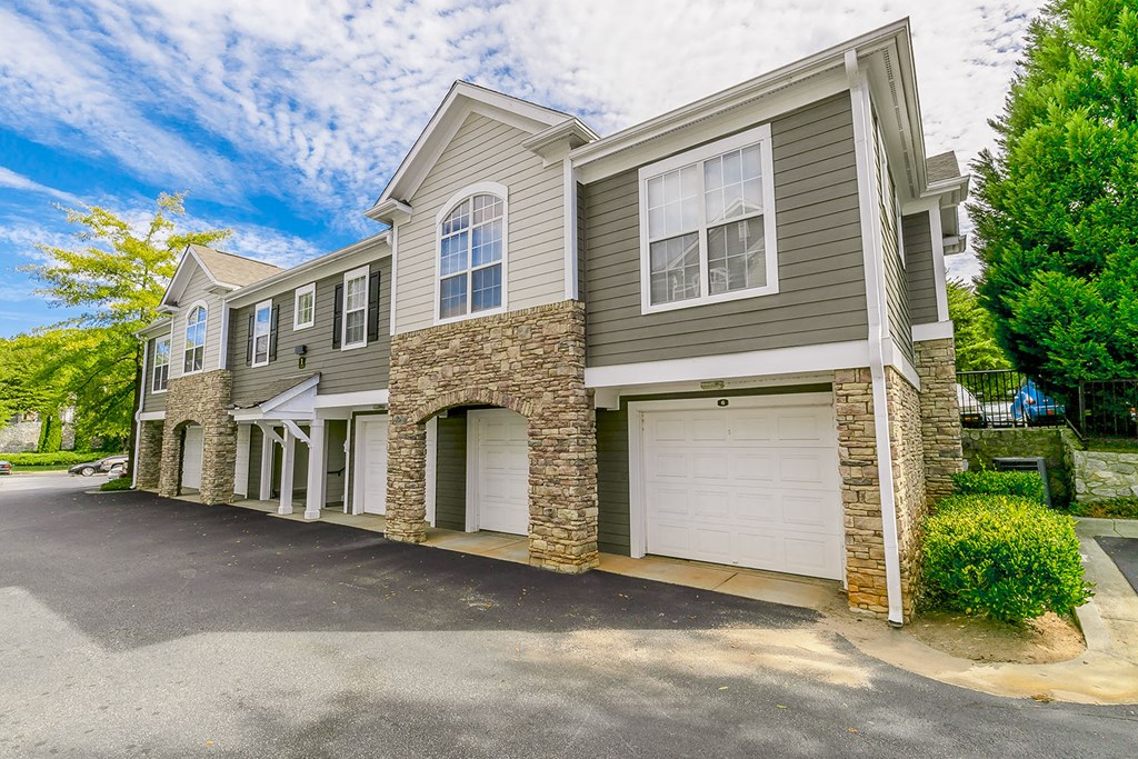 a beige and gray house with two garage doors